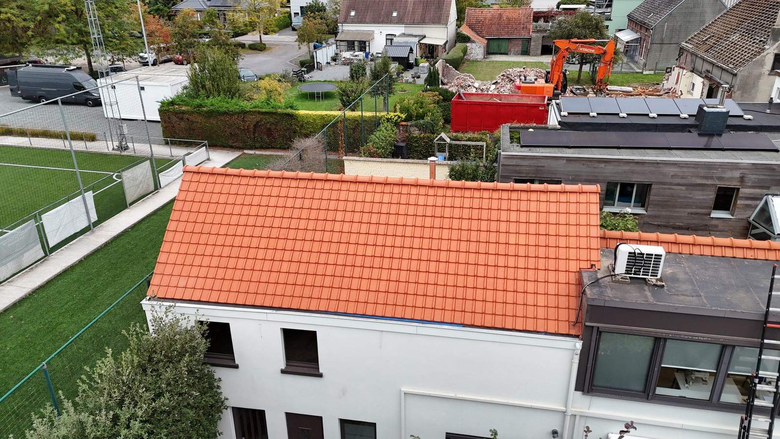 Dronebeeld van een dakrenovatie met nieuwe rode pannen