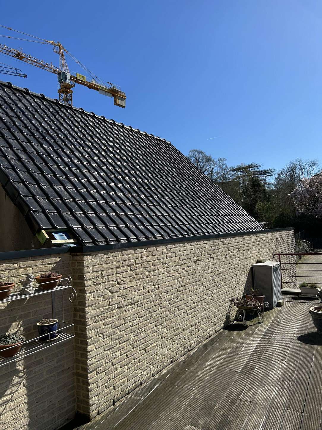 Hellend dak met nieuwe zwarte dakpannen na renovatie