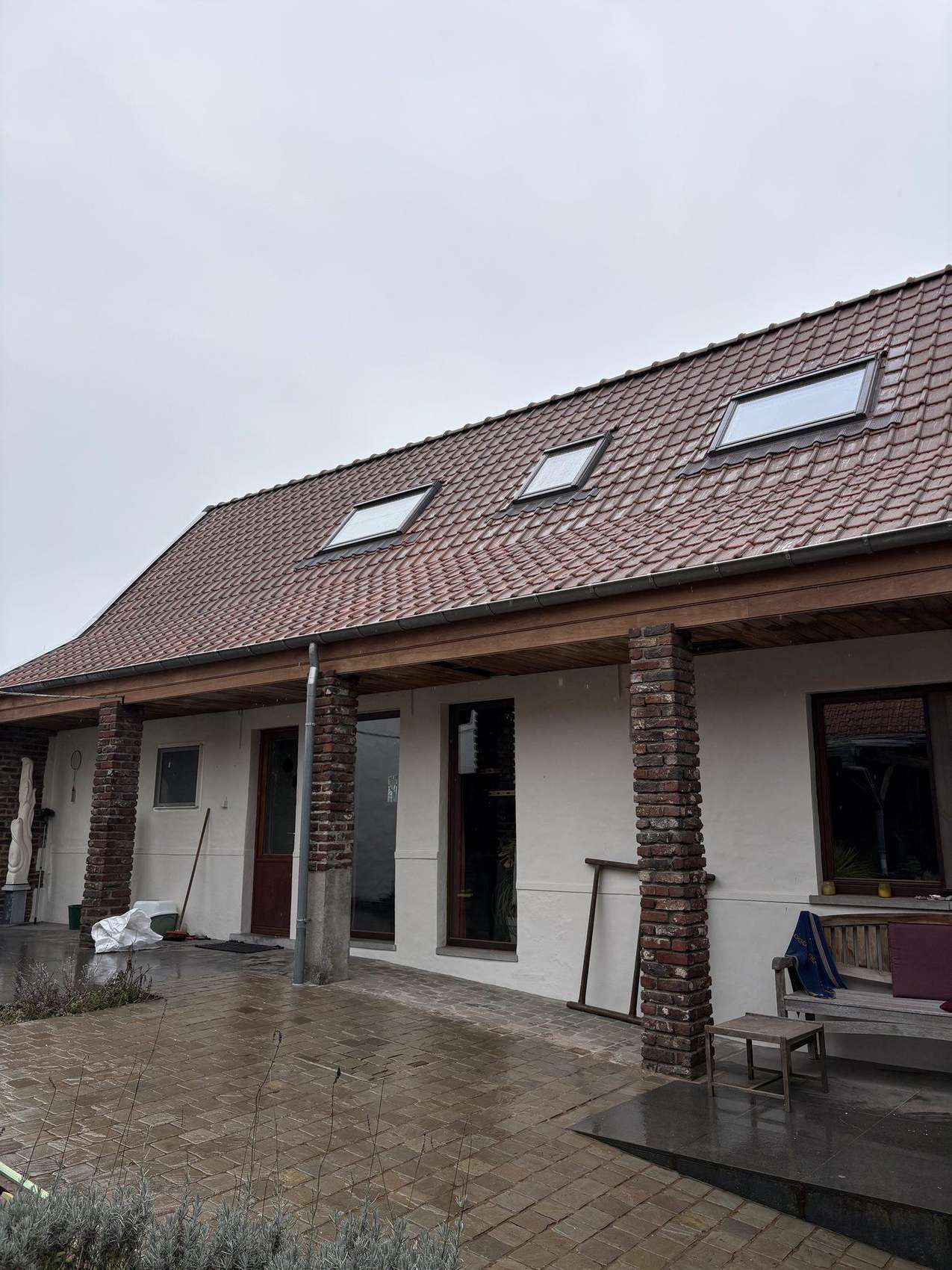 Hellend dak met drie dakvensters en nieuwe pannen